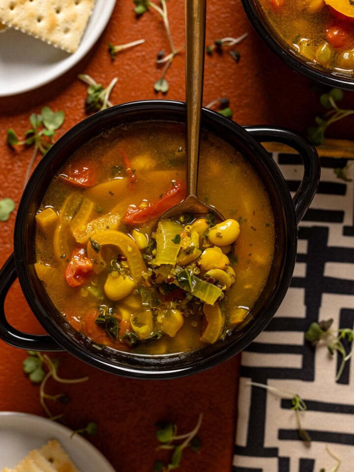 Up close shot of soup in a black bowl with a spoon.