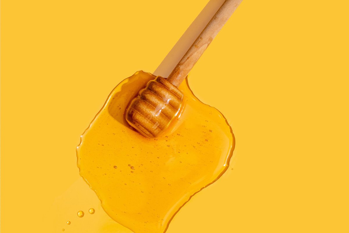 Honey spilled onto a yellow background.