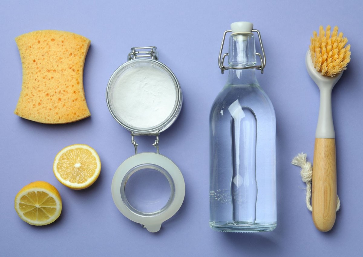 Cleaning essentials on purple background.