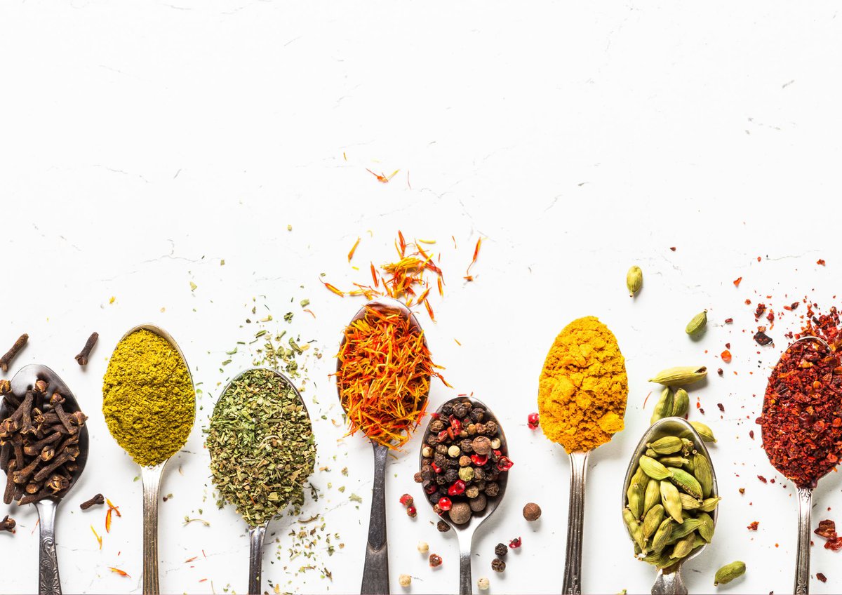 Spices in spoons on white background.