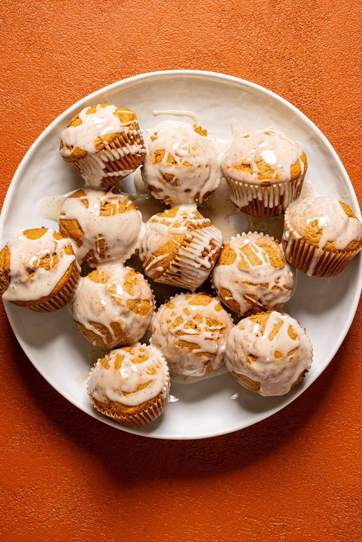 Gingerbread muffins with a glaze on a white platter.