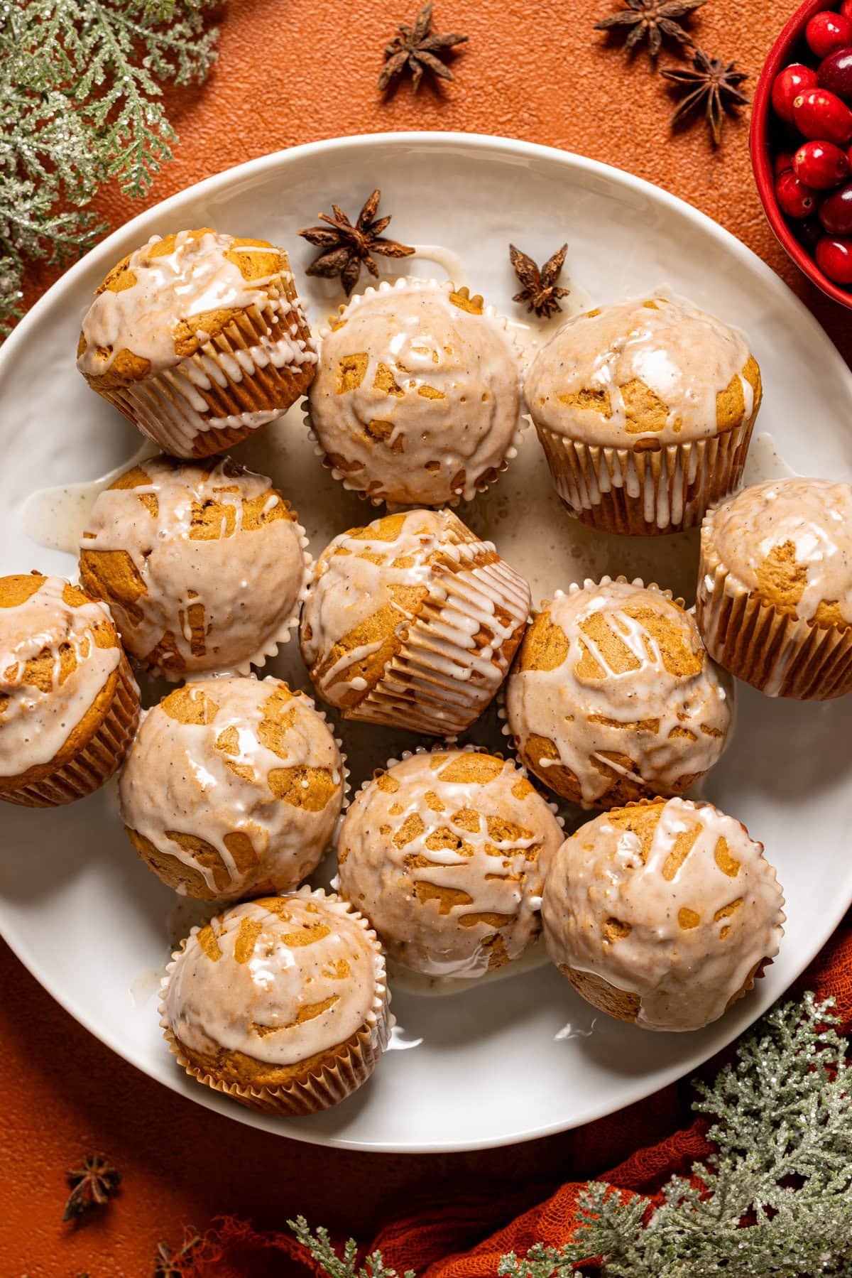 Gingerbread muffins on a white platter with Christmas decor.