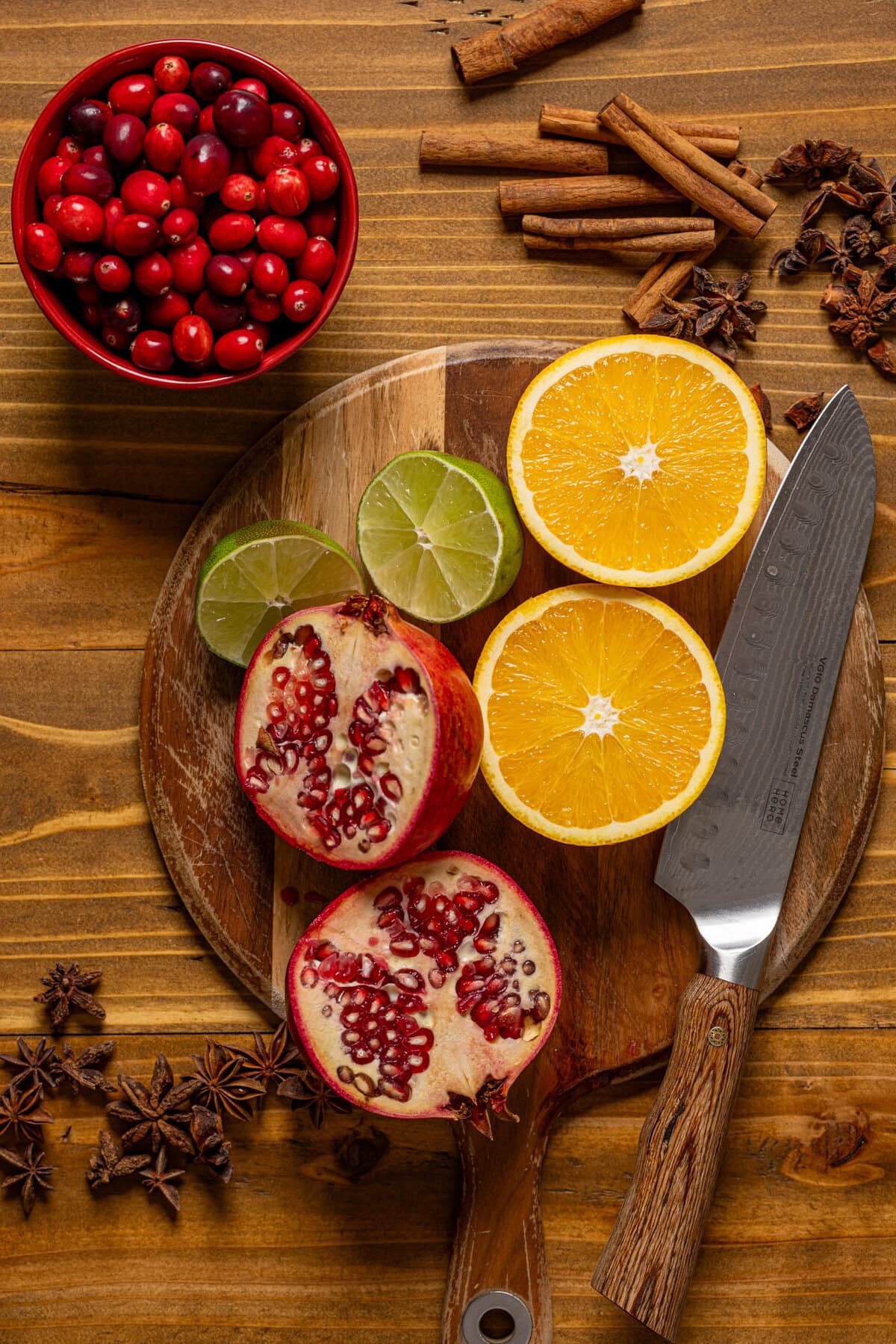 Sliced fruit and ingredients on a brown wood table with a cutting board and knife.