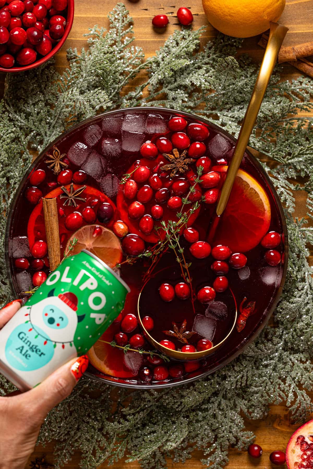 A can of Olipop being poured into a bowl with Christmas Punch.