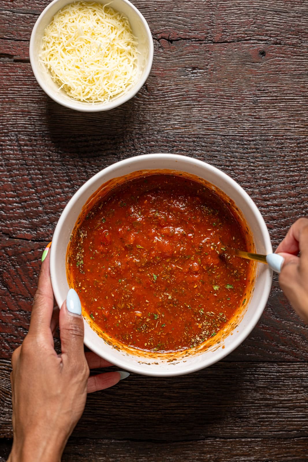 Marinara sauce in a bowl being stirred.