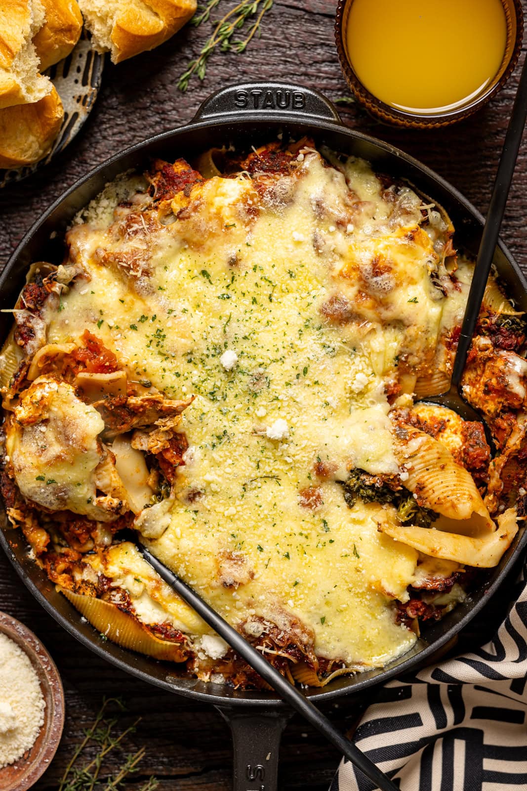 Stuffed shells scooped with two spoons in a skillet.