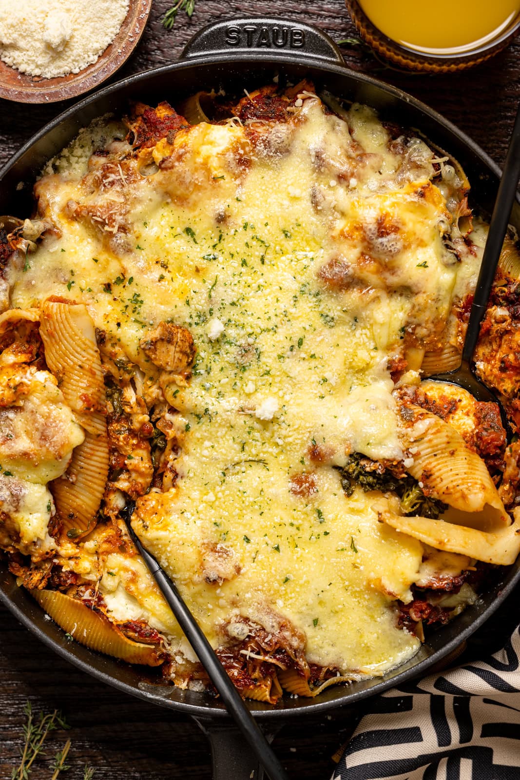 Up close shot of stuffed shells in a skillet with two spoons.
