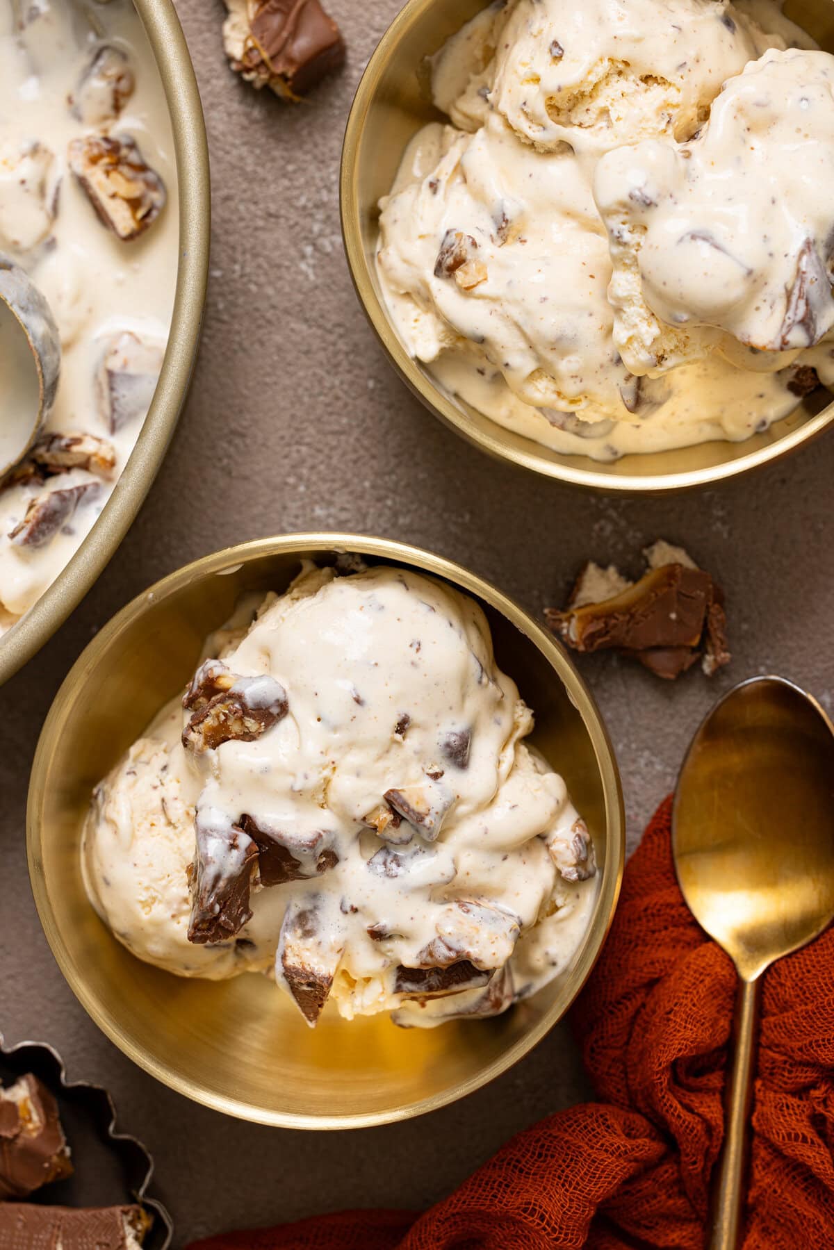 Up close shot of ice cream in two gold bowls with a spoon.