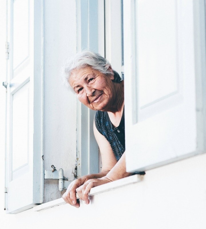 Smiling woman leaning out of a window.