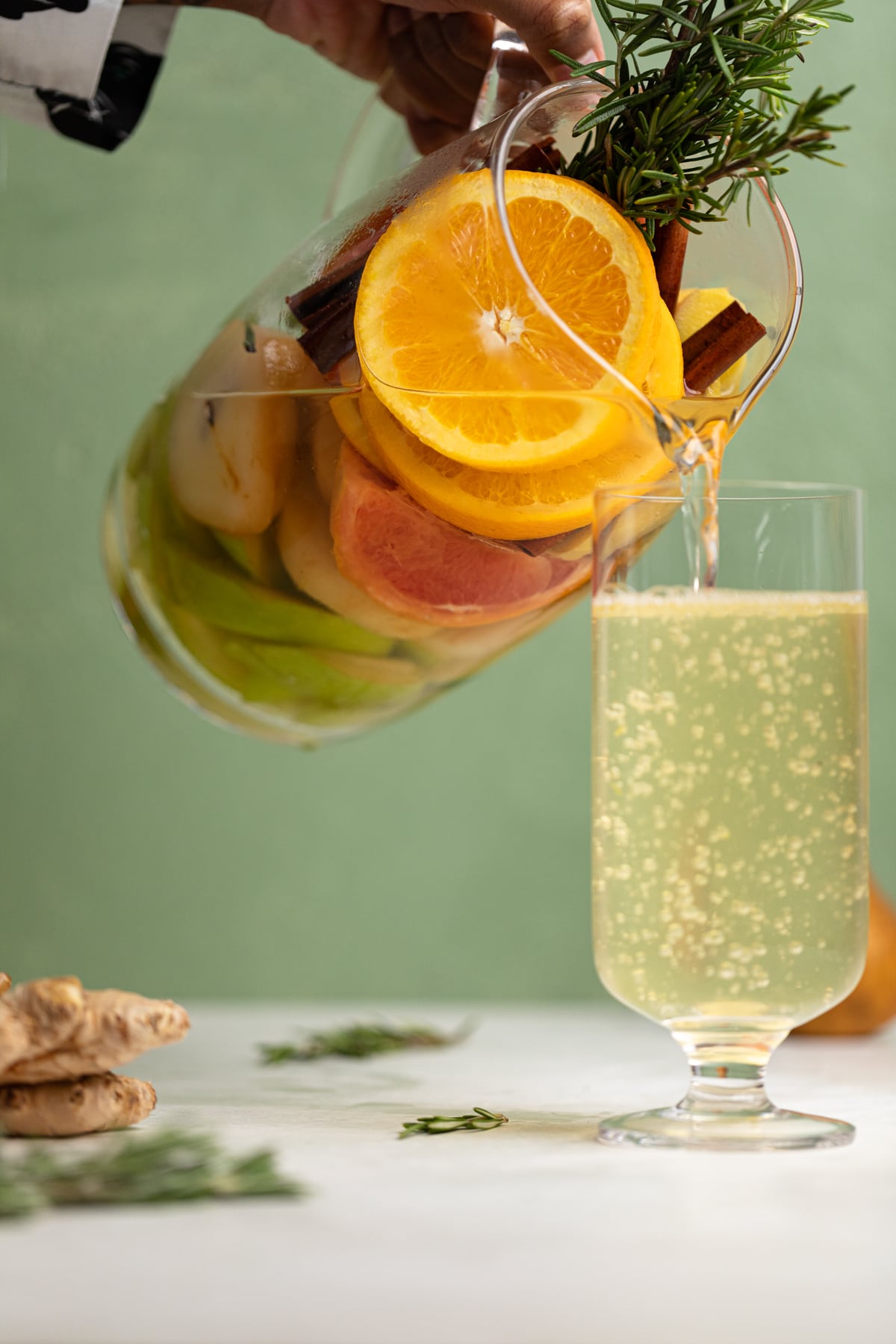 Citrus Ginger Pear Detox Infused Water being poured into a tall glass.