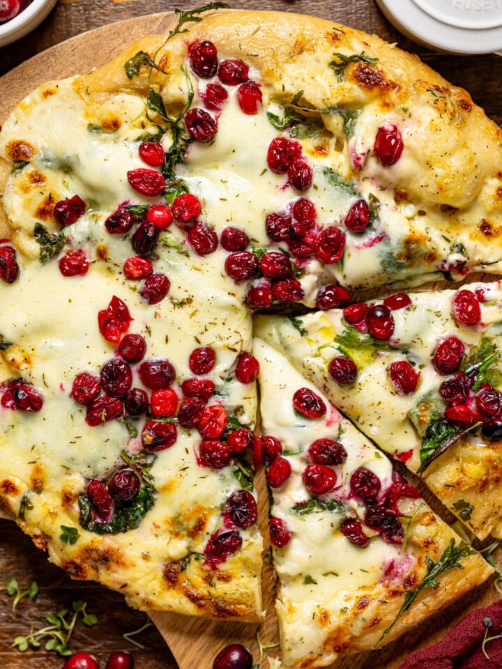 Pizza with two slices and cranberries.