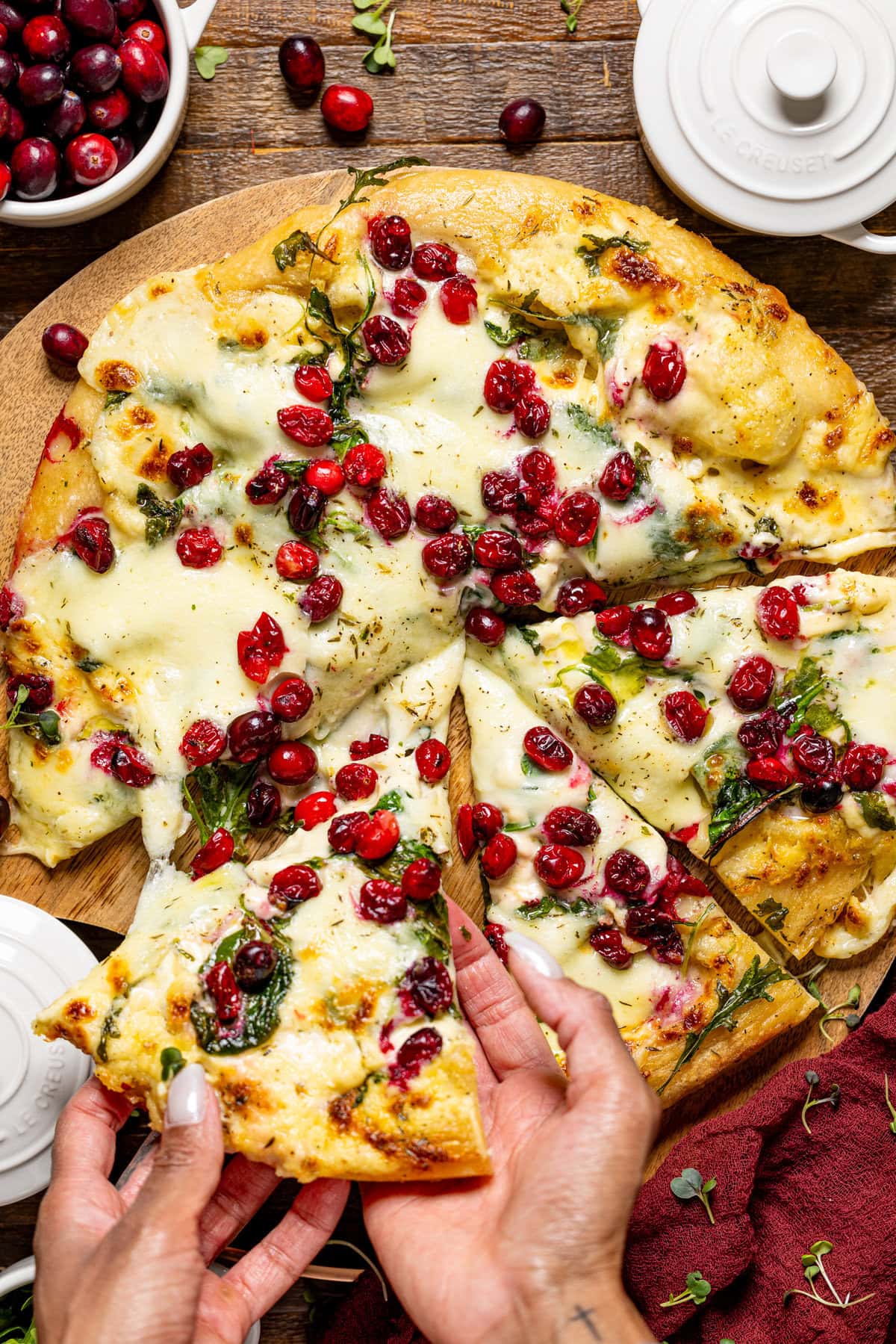 Female hand lifting a slice of Thanksgiving pizza.