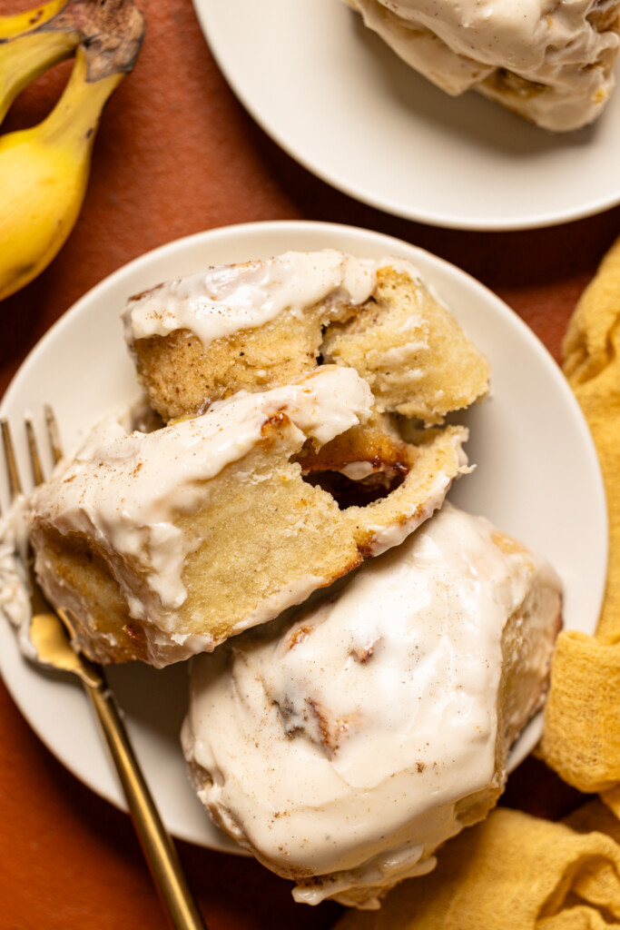 Up close shot of cinnamon rolls on a plate with a fork.