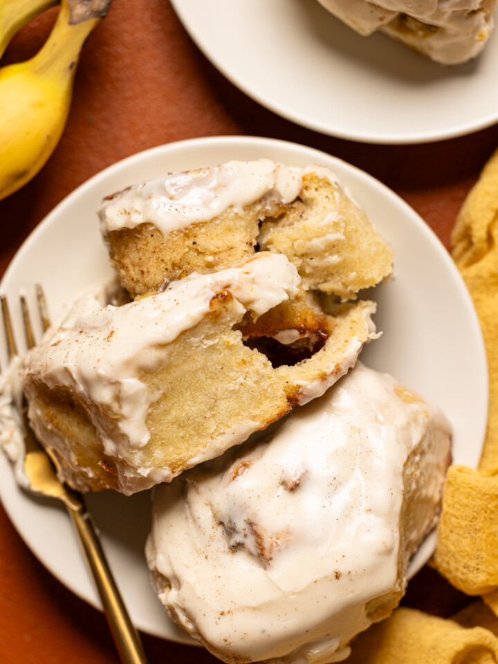 Up close shot of cinnamon rolls on a plate with a fork.