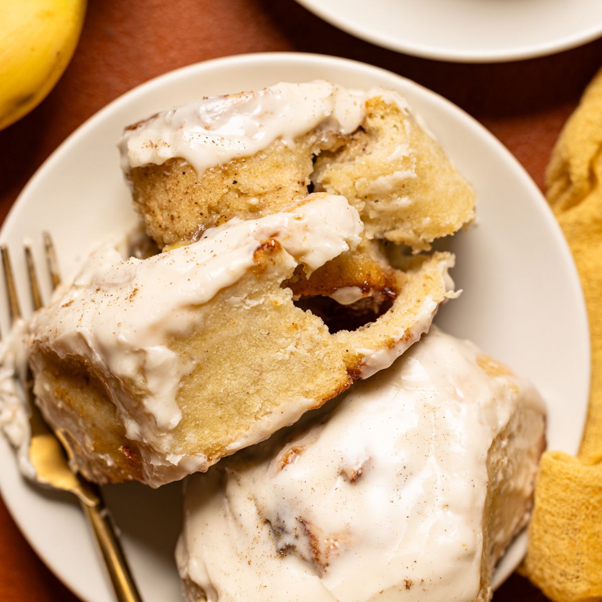 Up close shot of cinnamon rolls on a plate with a fork.