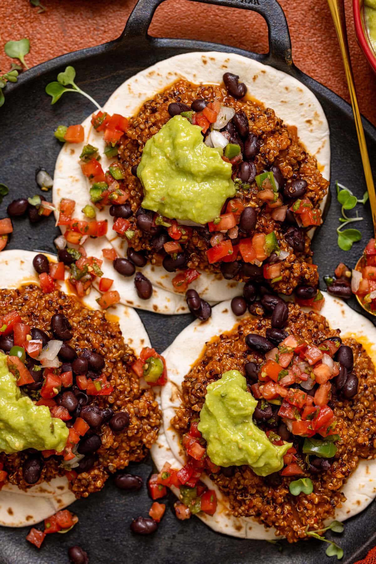 Sofritas tacos on a black low skillet with a spoon.