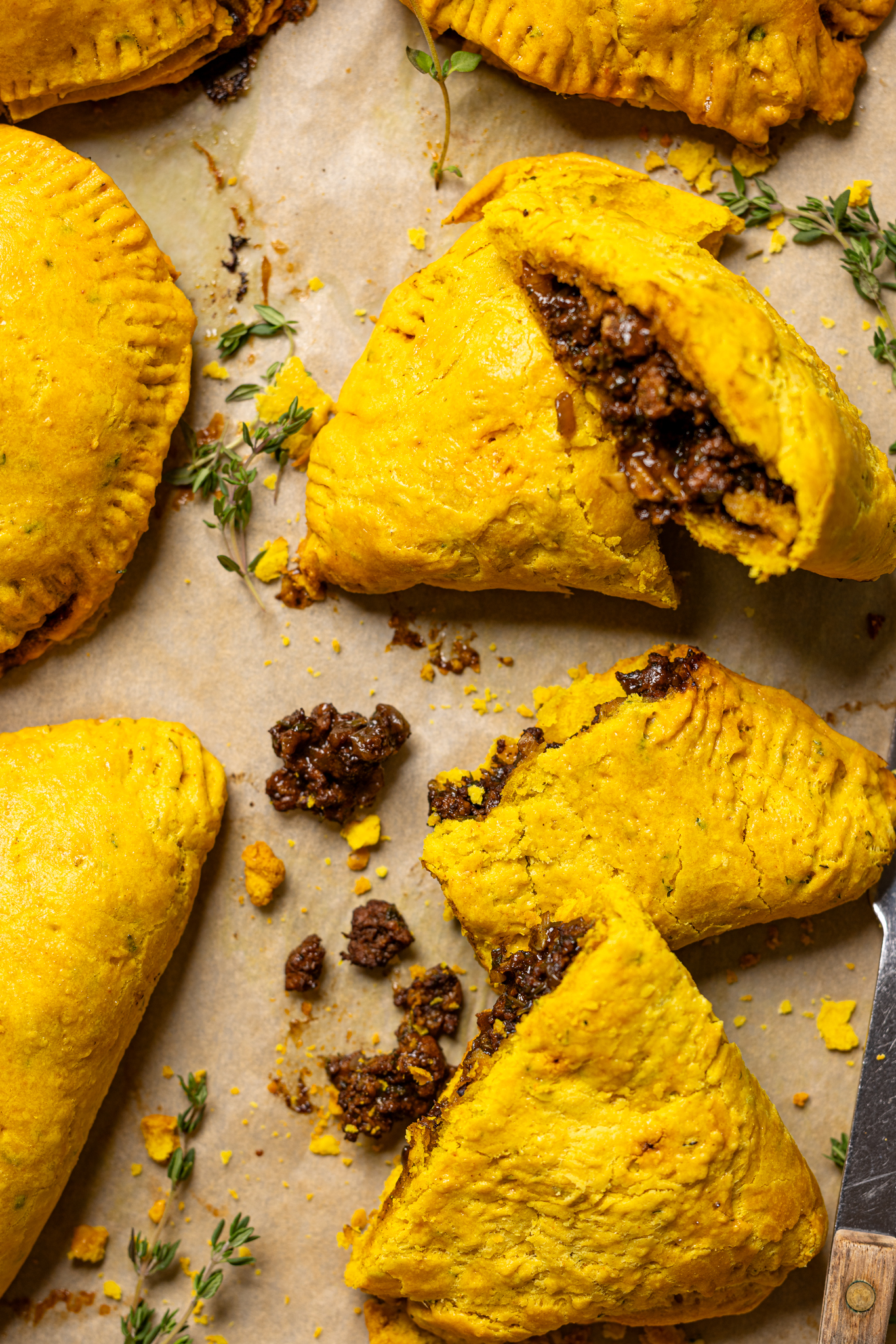 Image of beef patties on a baking sheet with meat filling falling out.