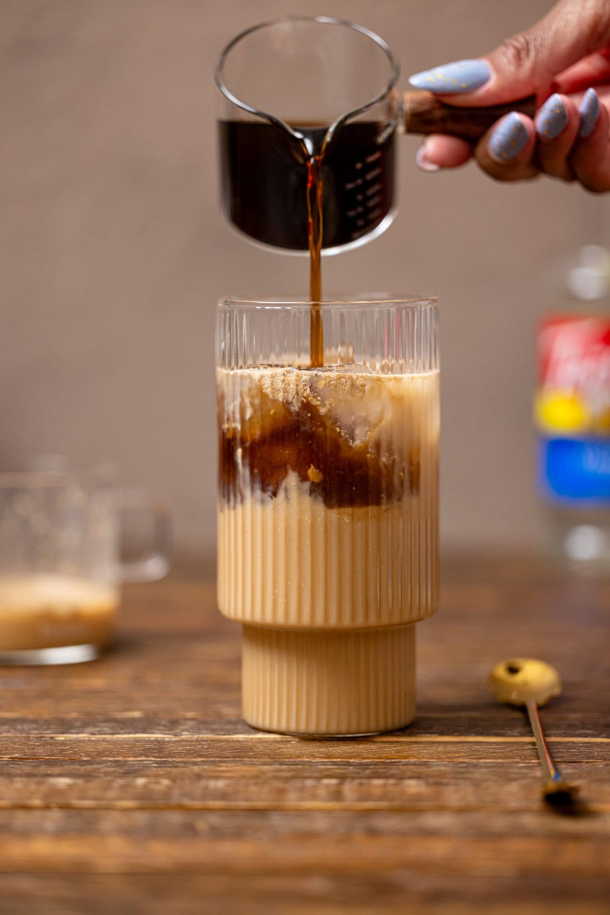 Brewed coffee being poured into chai mixture.