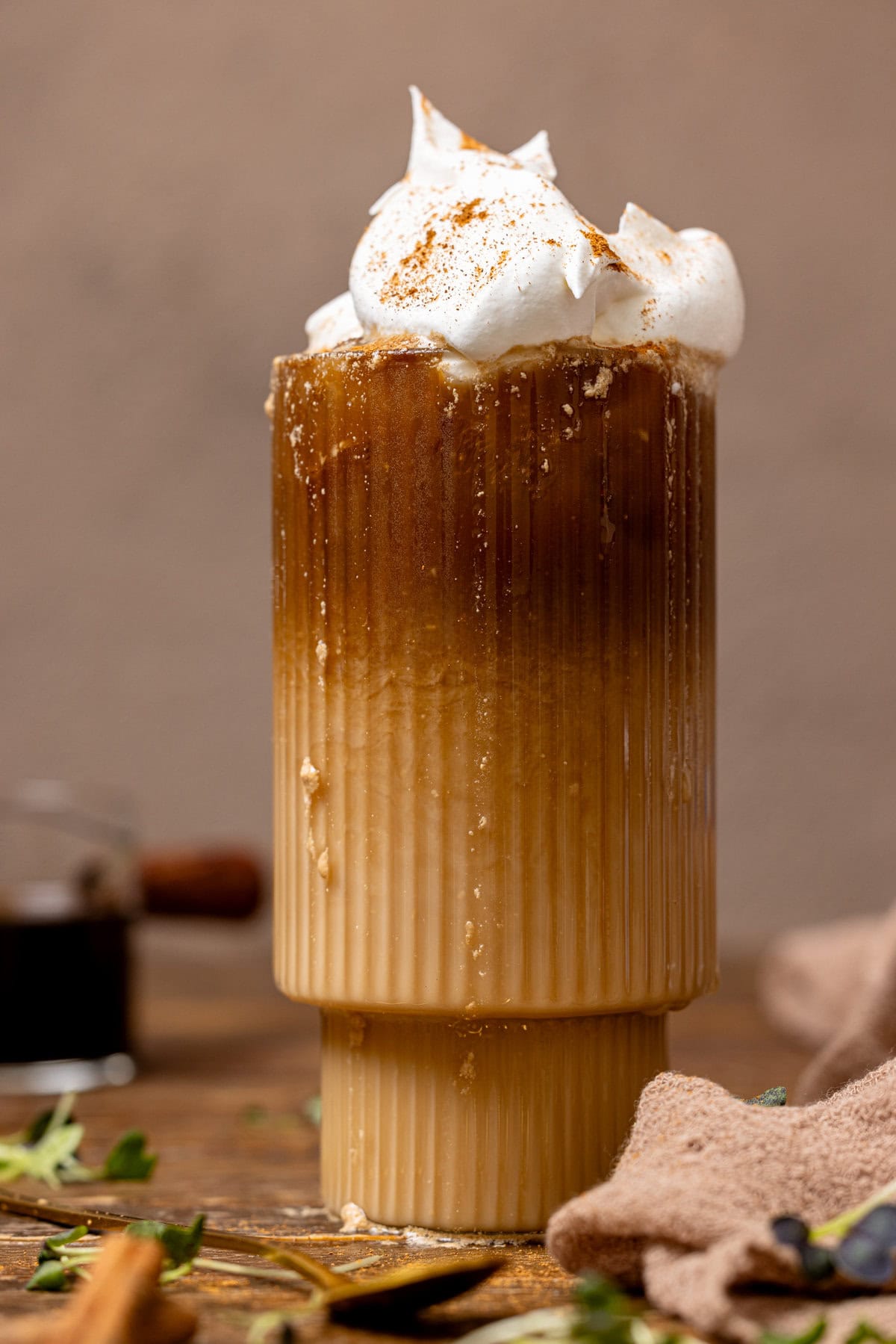 Up close shot of dirty chai latte with whipped cream.