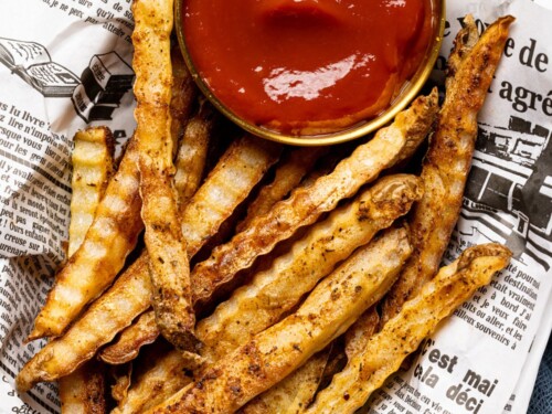 Seasoned French Fries in Paper Bag with Wooden Fork and Ketchup