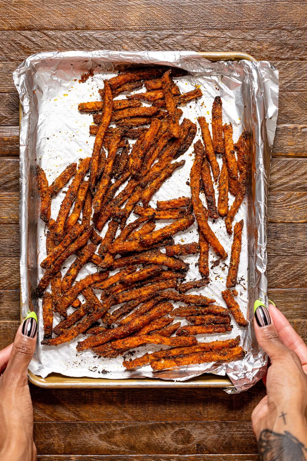 Baked sweet potato fries on a baking sheet with foil.