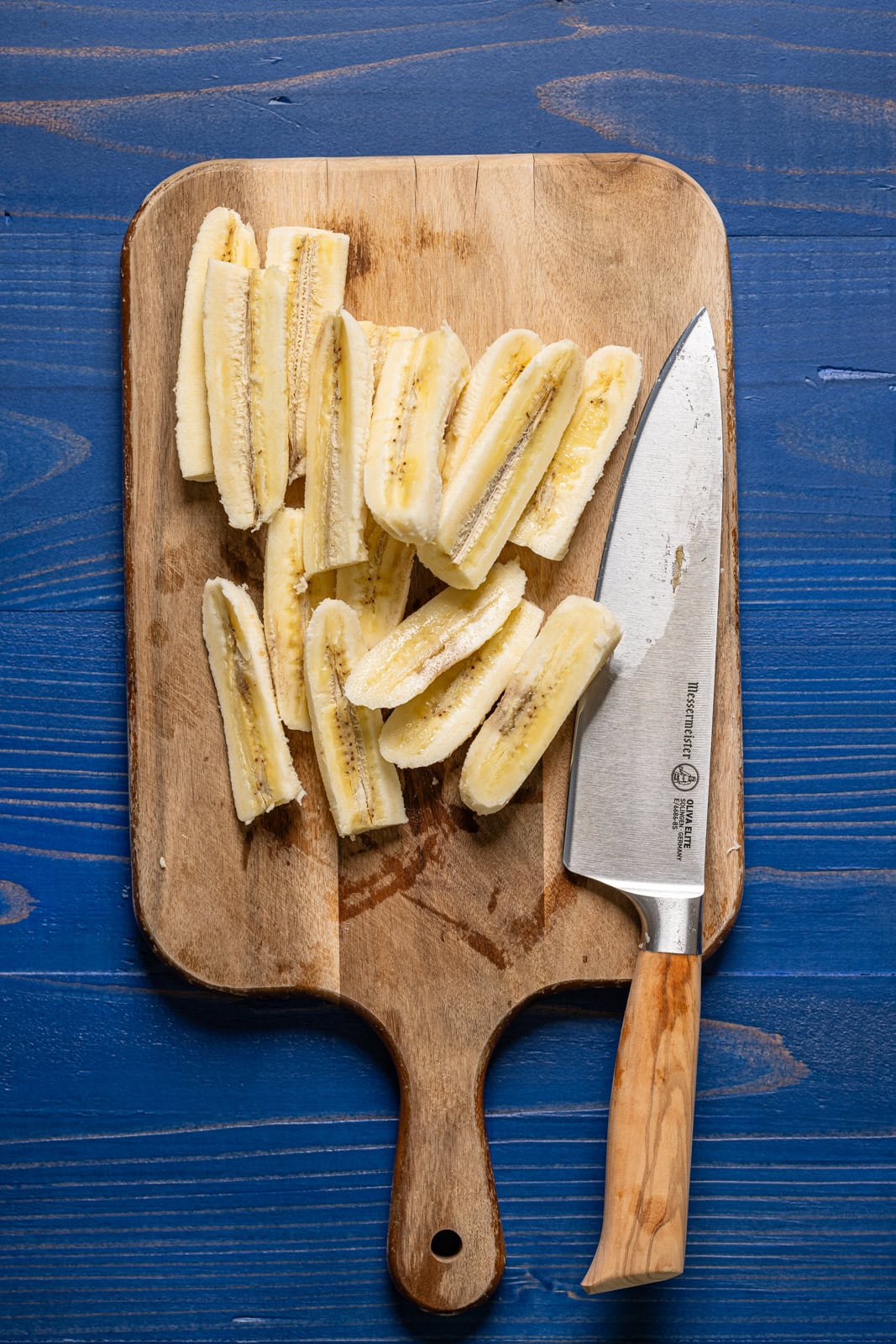 Sliced banana on a cutting board with a knife.