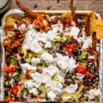 Up close shot of nachos on baking sheet.