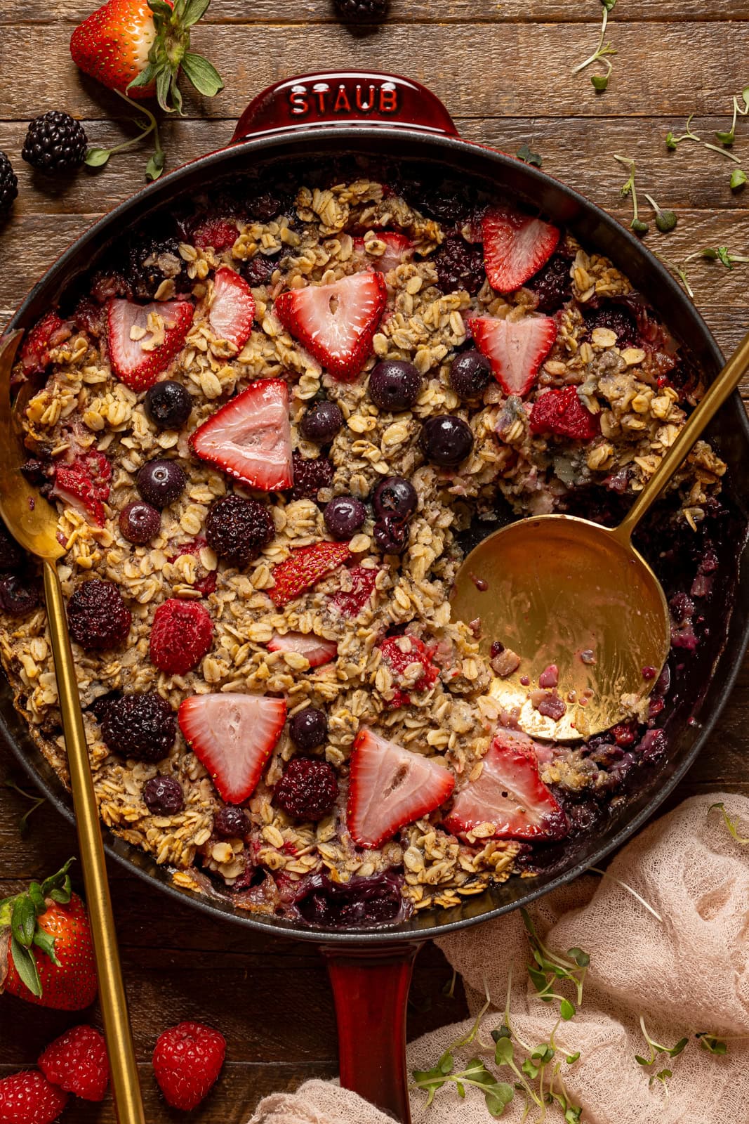 Baked oatmeal scooped in a skillet with gold spoons.