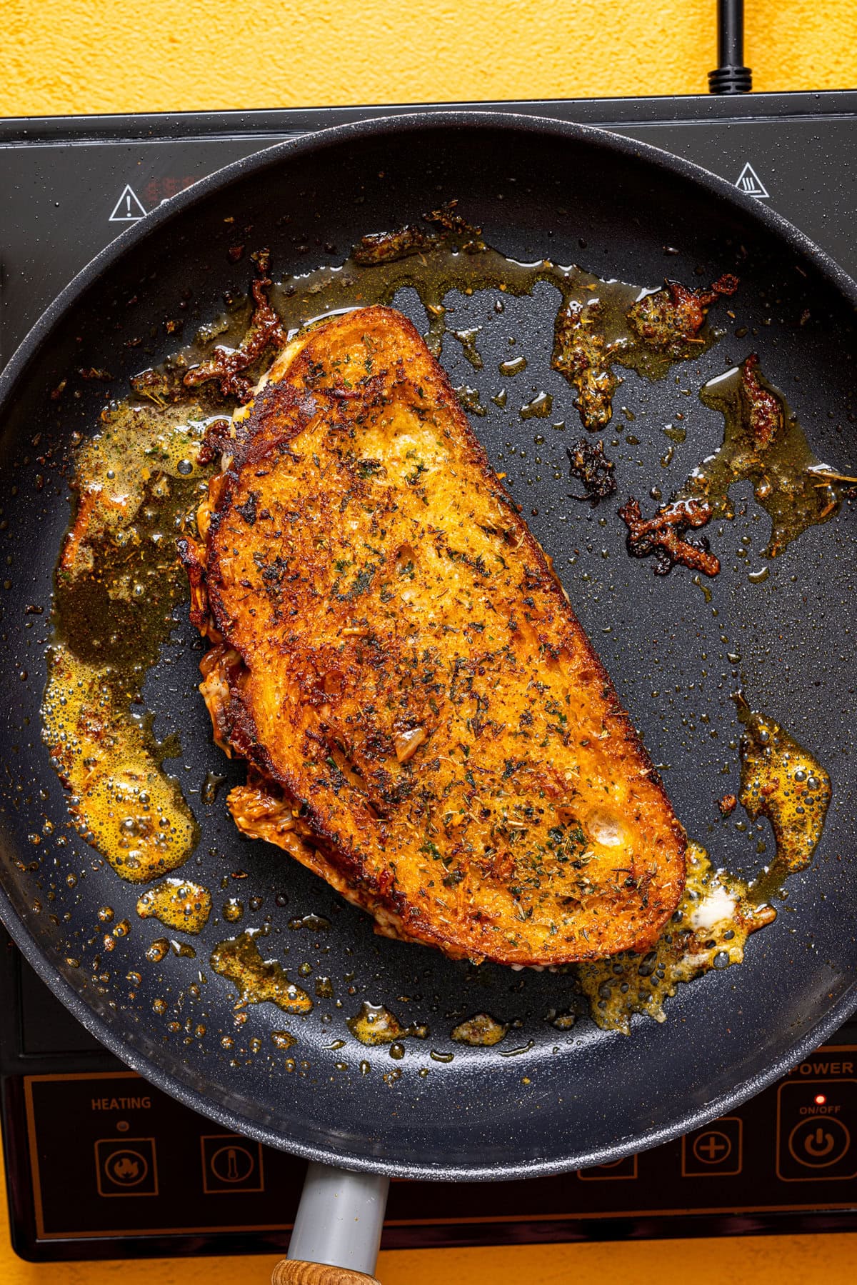 Grilled cheese in a skillet over the stovetop.