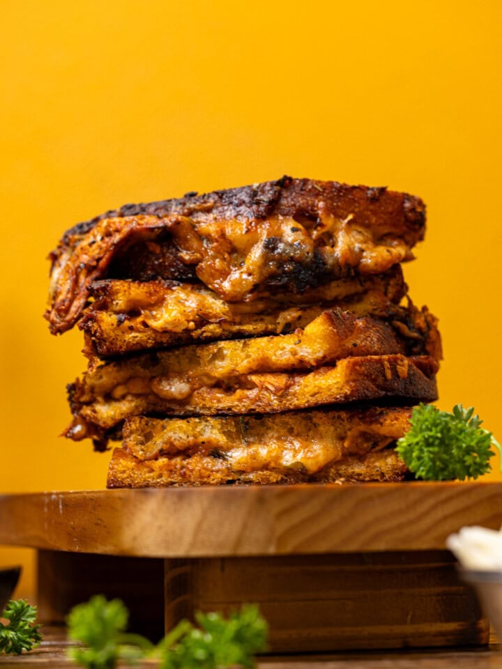 Stack of grilled cheese with a yellow background.