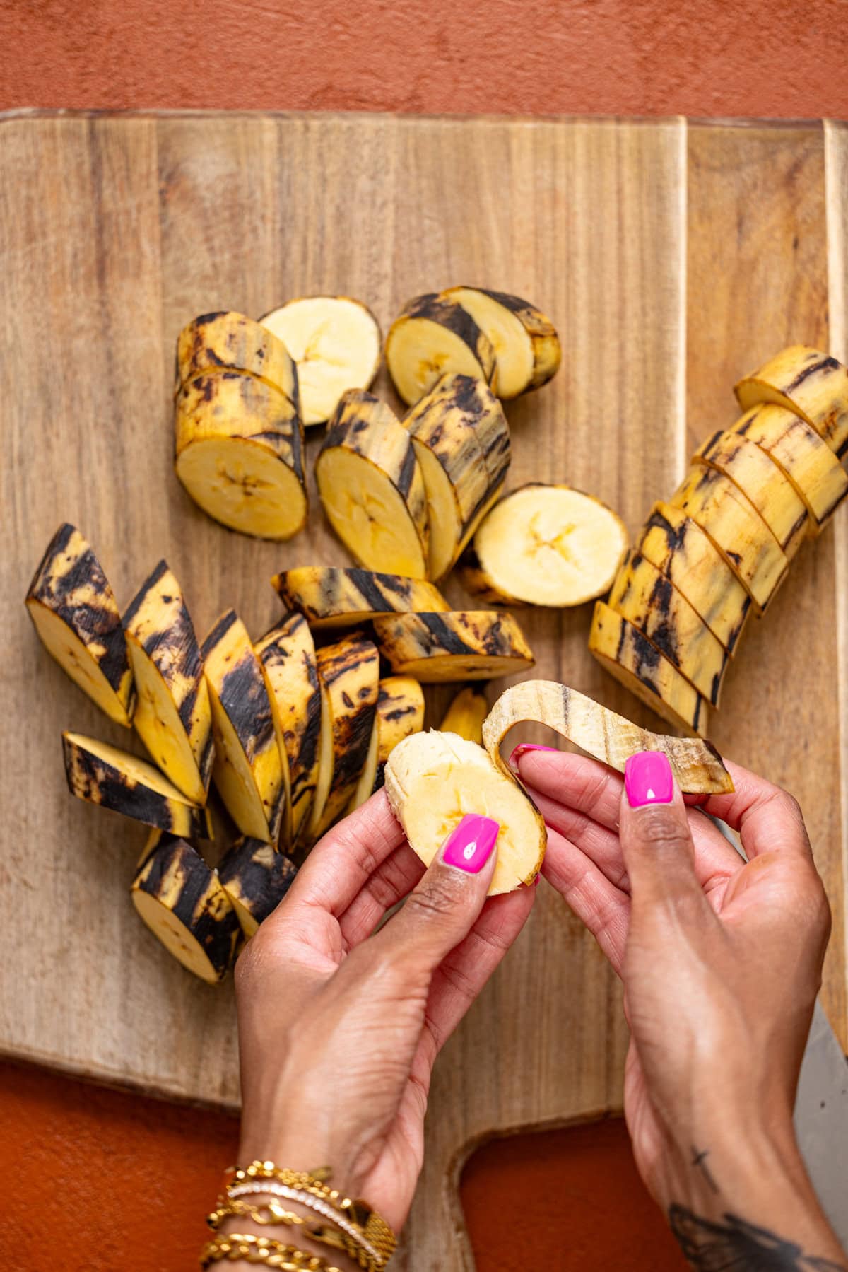 Plantains being peeled with hands.