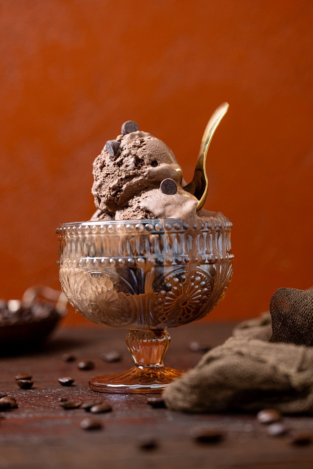 Forward shot of chocolate ice cream with a gold spoon.