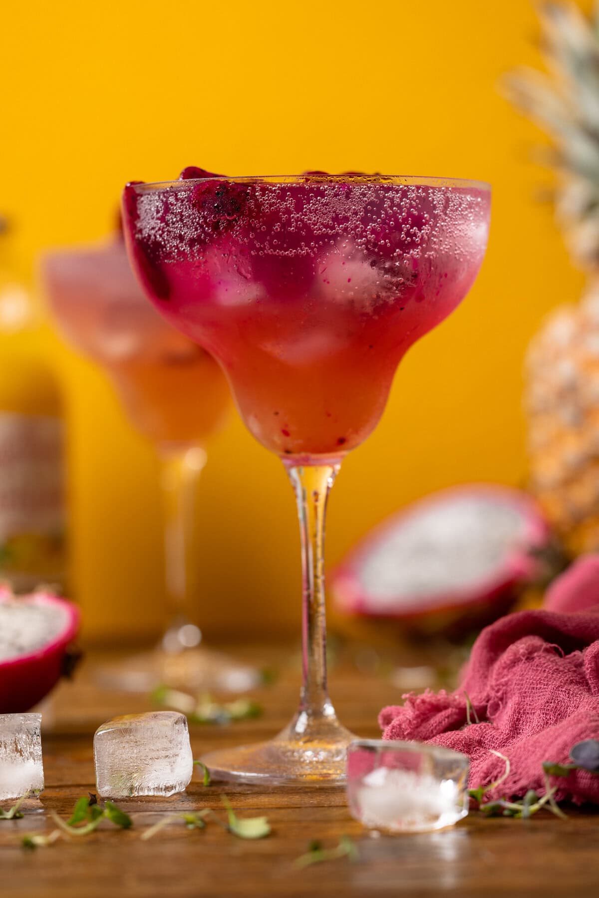 Two glasses of mocktail with dragonfruit and ice cubes.