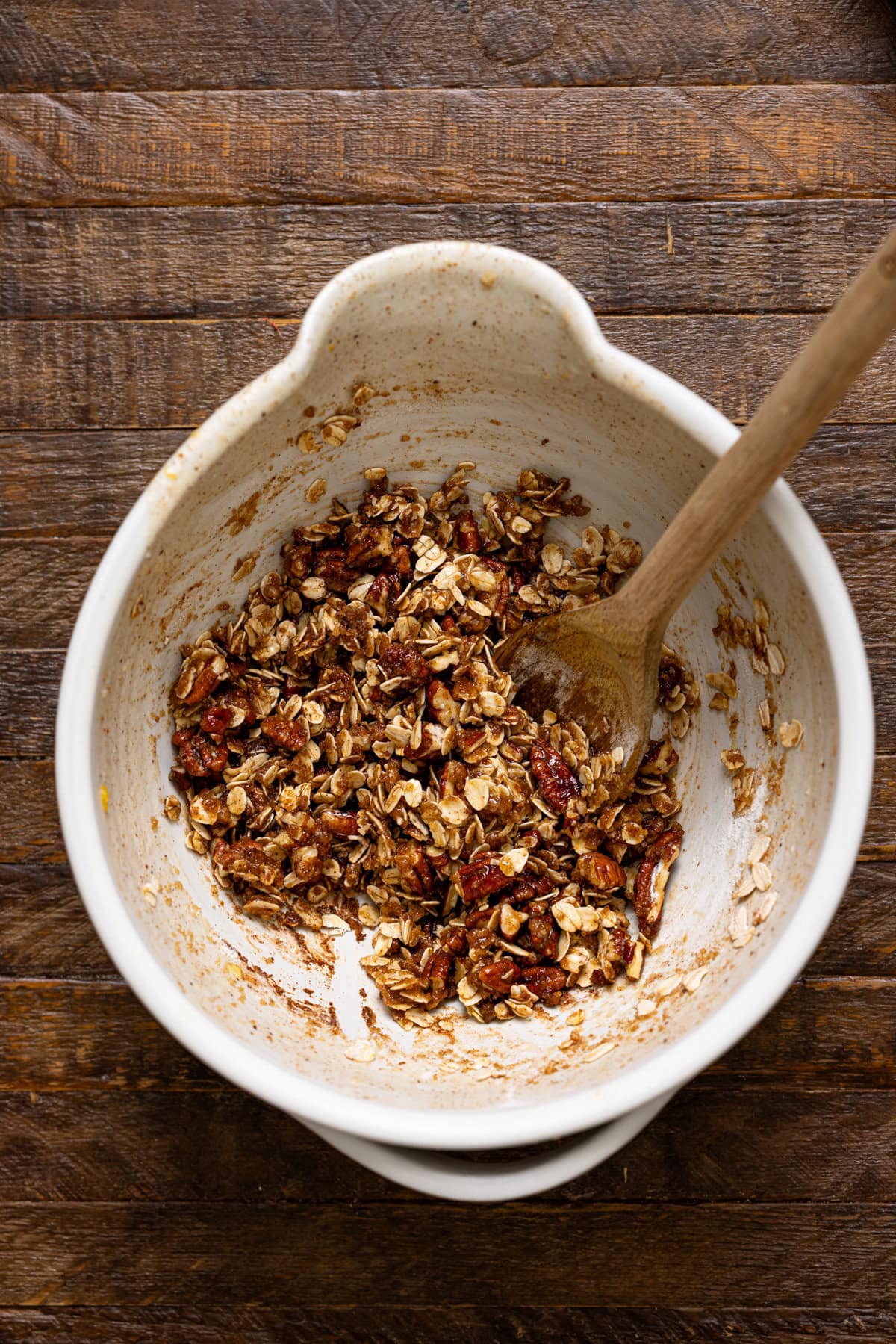 Topping ingredients in a white bowl with a wooden spoon.