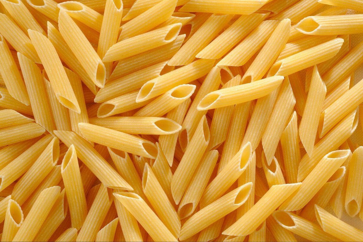 Penne pasta laid on table.