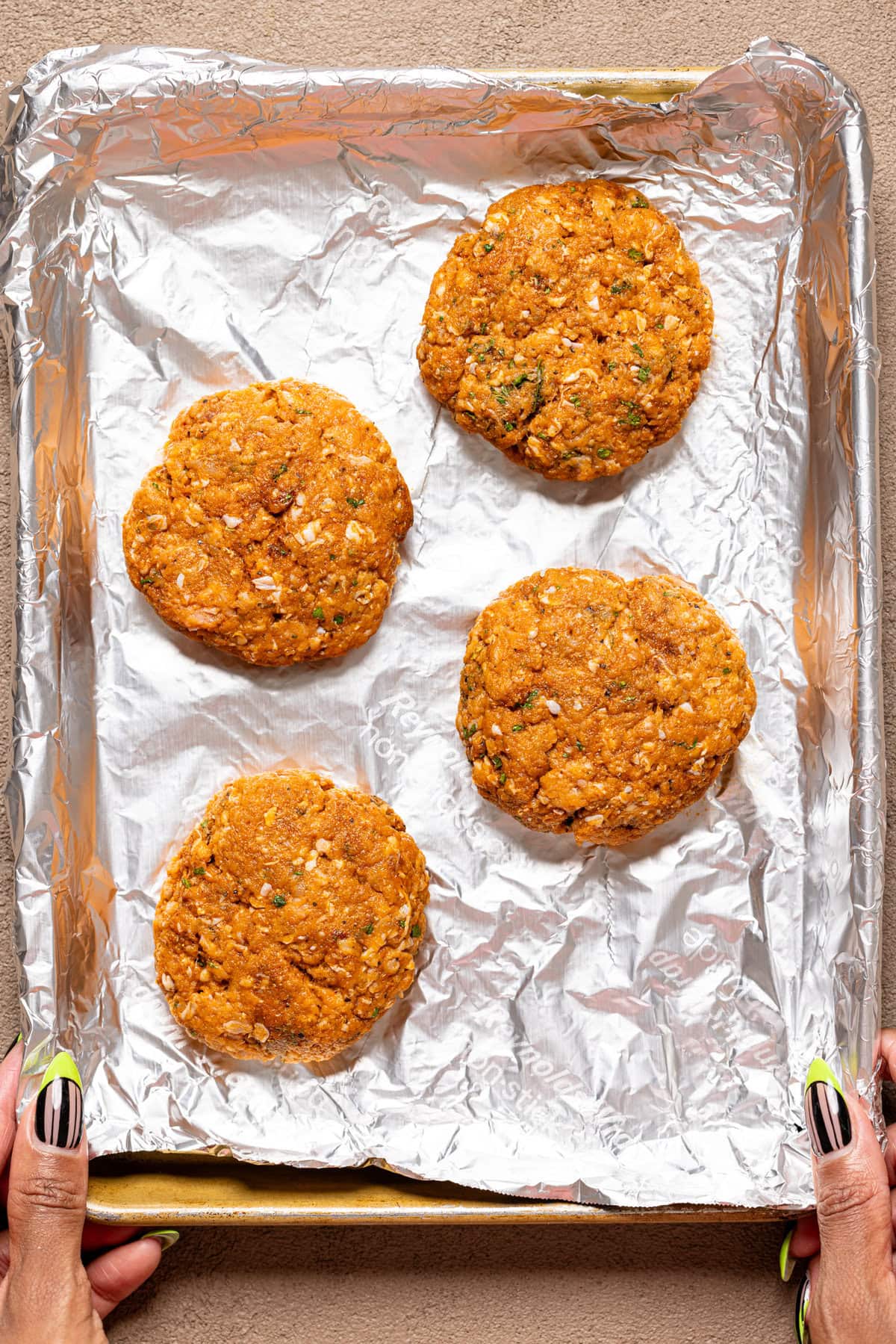 Turkey patties lined on a baking sheet with foil paper.