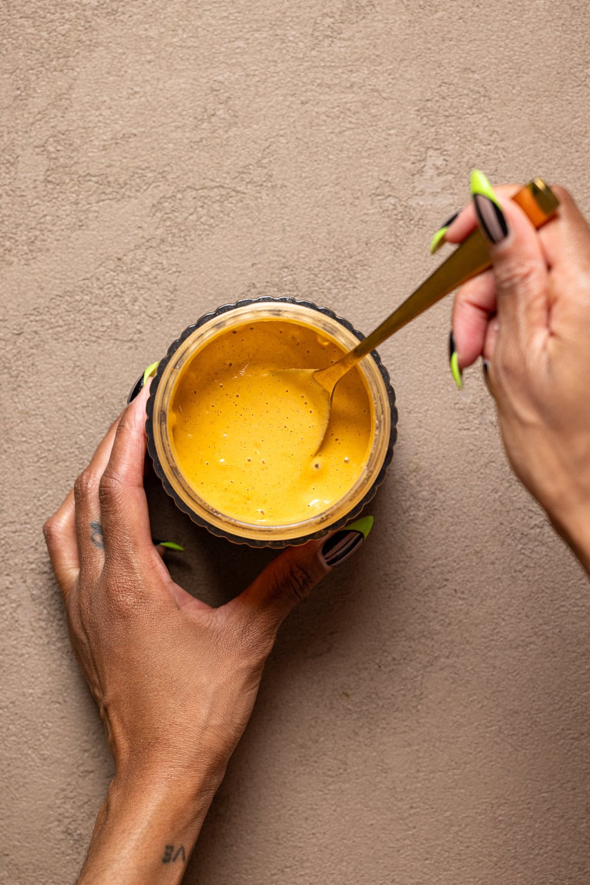 Chipotle sauce being stirred with a spoon.