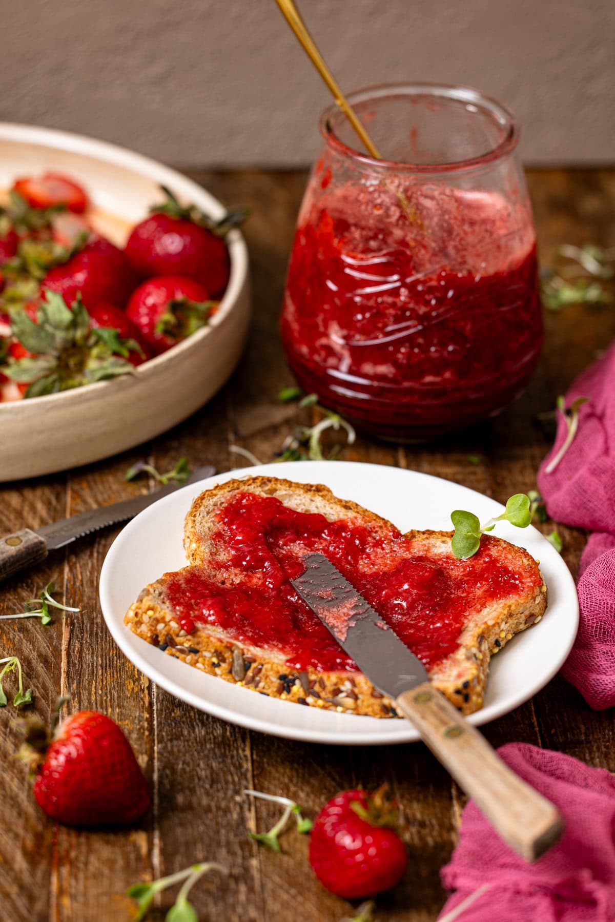 Toast with strawberry jam and a knife with strawberries. 