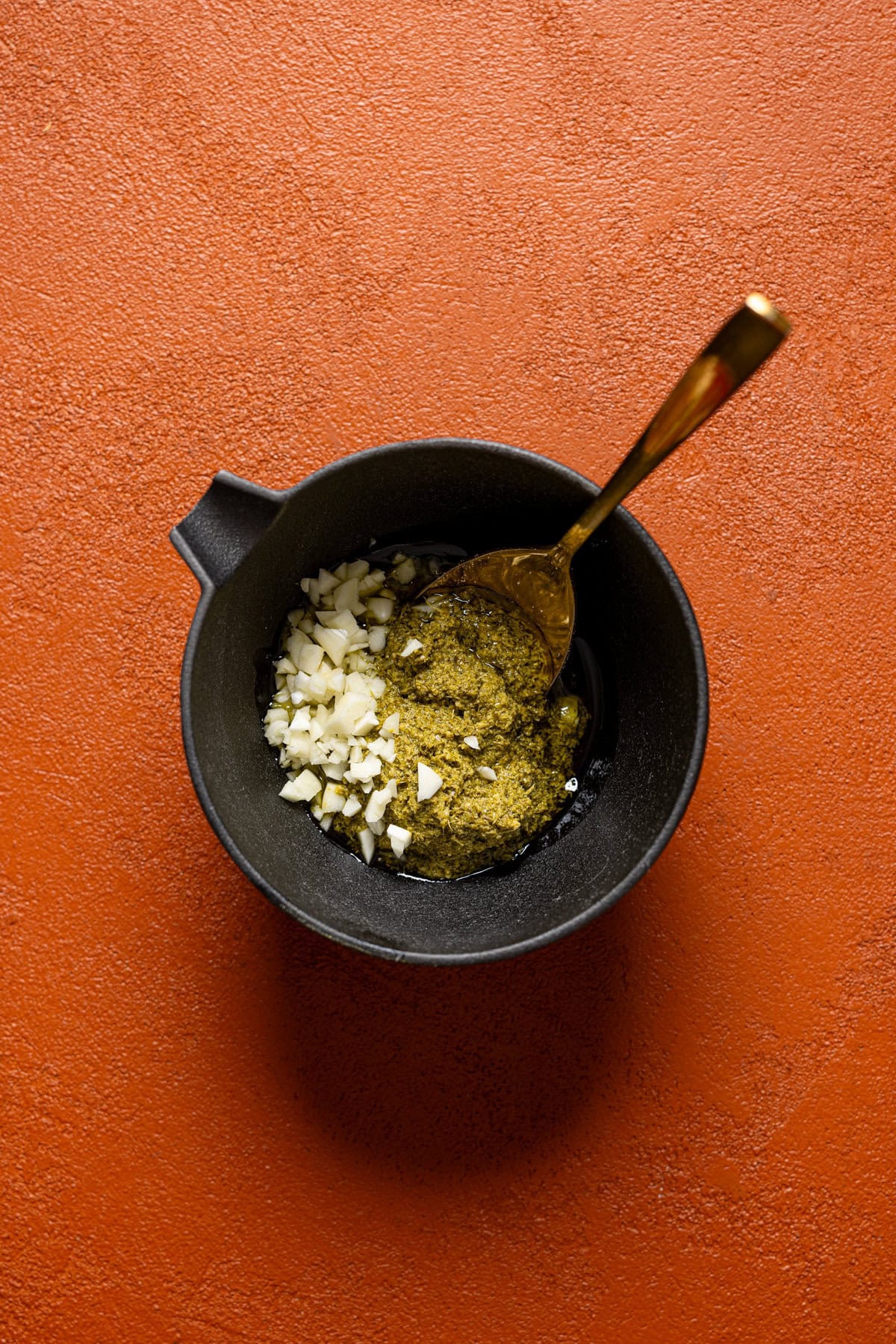 Topping ingredients in a black bowl with a spoon.