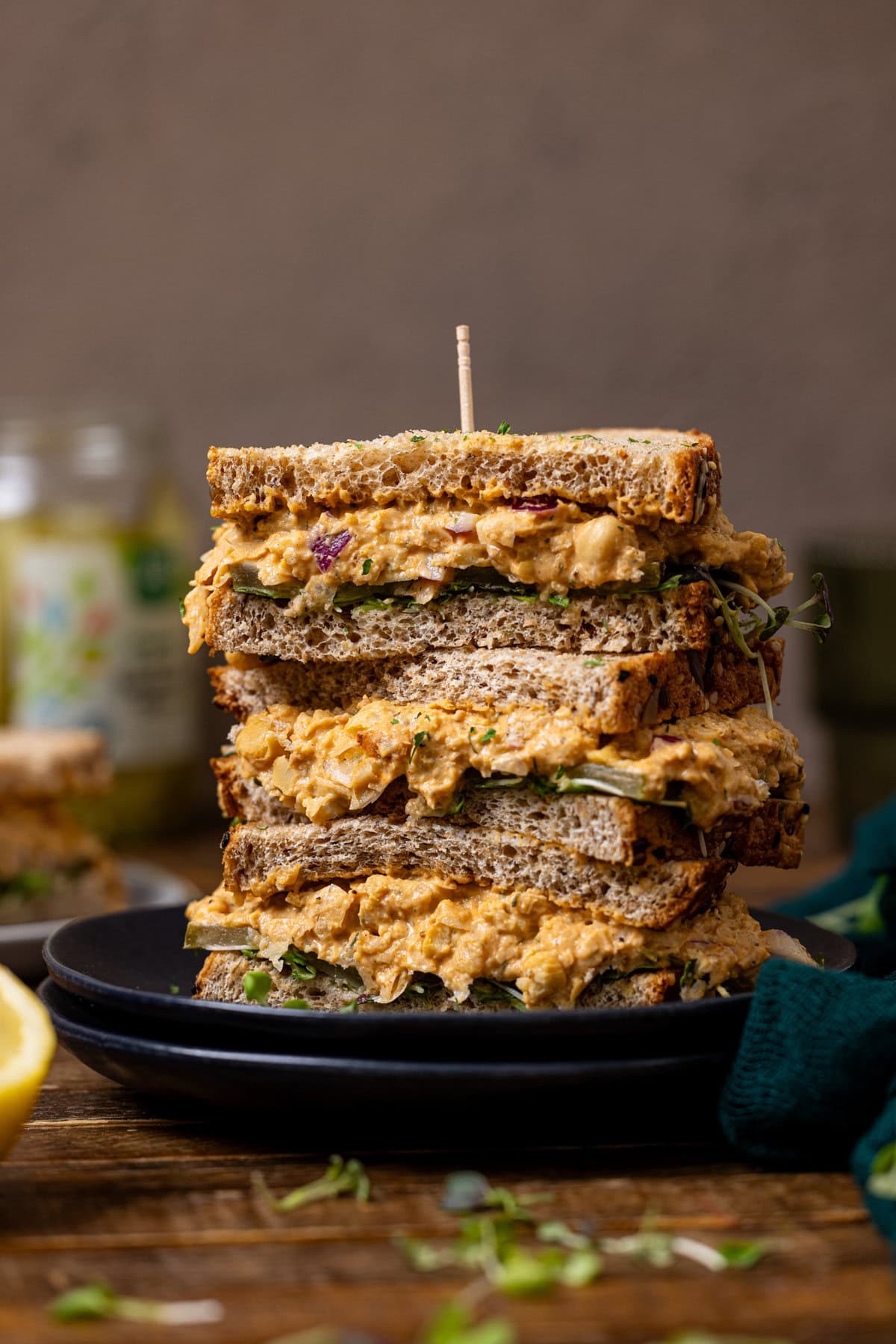 Cut sandwiches perfectly stacked on plates with a toothpick.