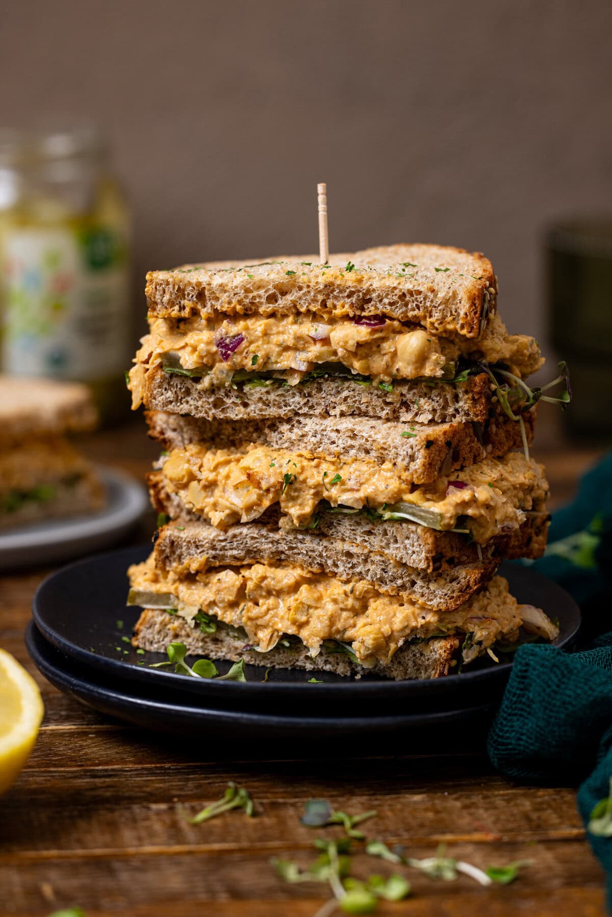 Three sandwiches stacked on each other with a toothpick.