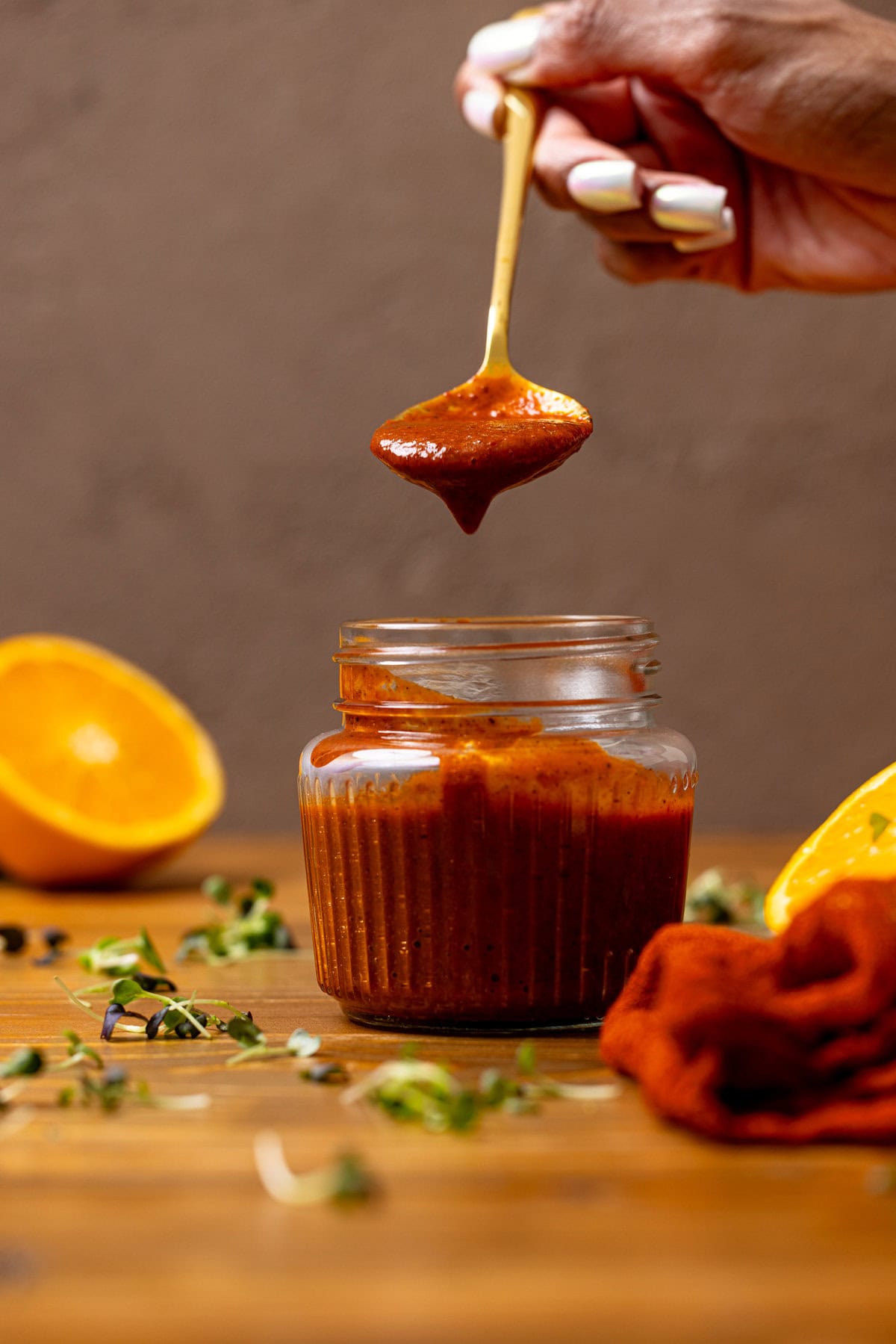 Al Pastor Marinade in a mason jar with a spoon being held with marinade.