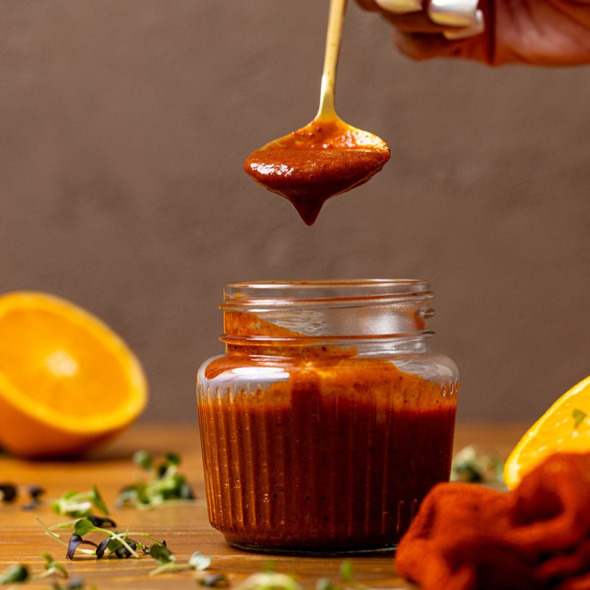 Al Pastor Marinade in a mason jar with a spoon being held with marinade.