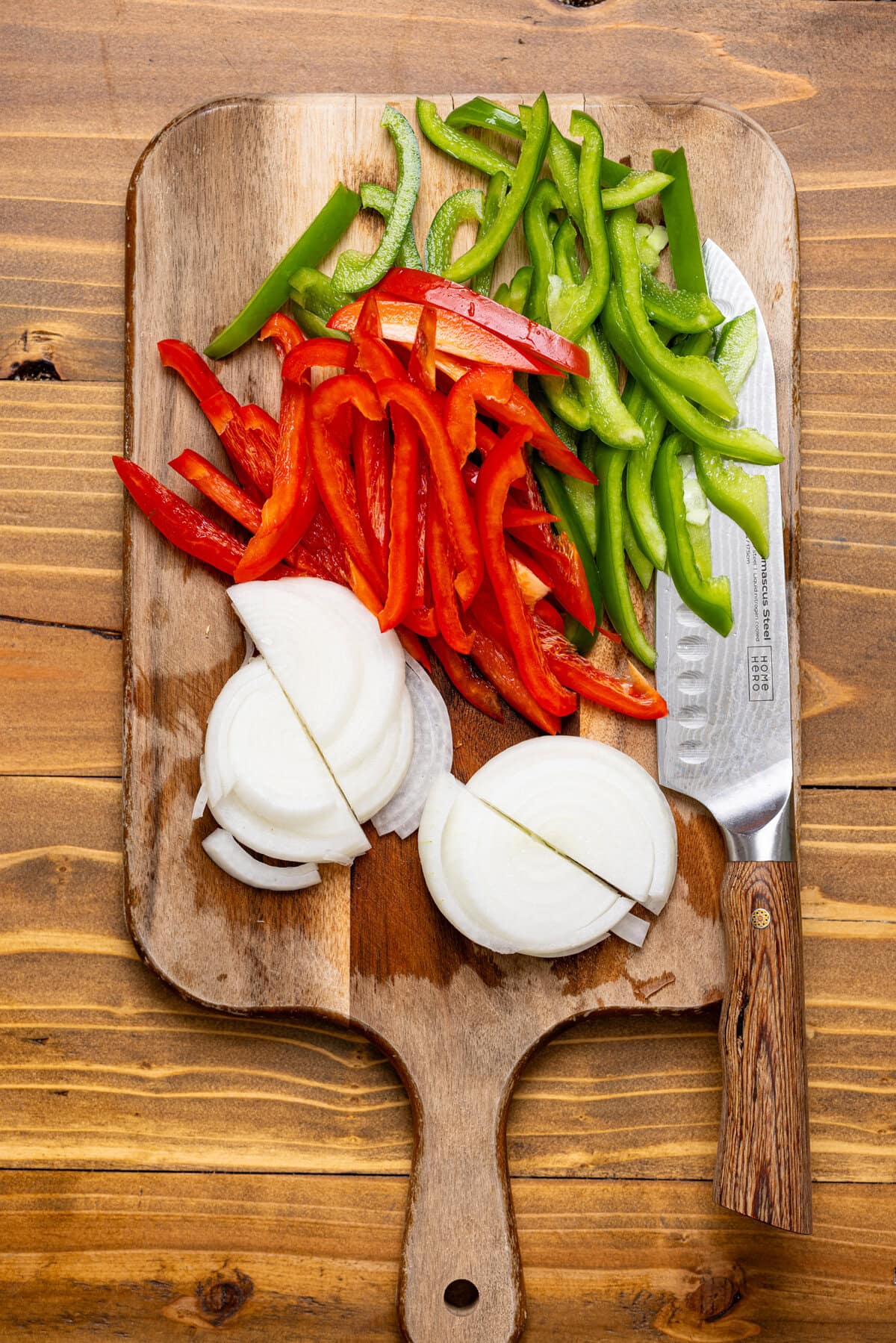 Chopped veggies on a cutting board with a knife.