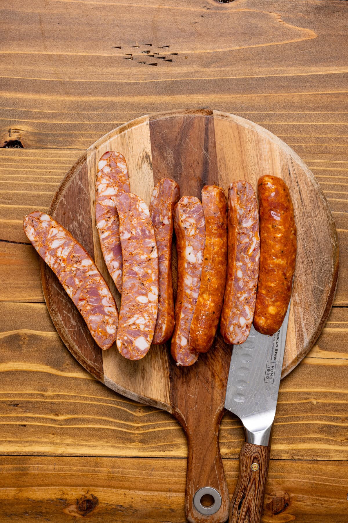 Sliced sausages on a cutting board with a knife.