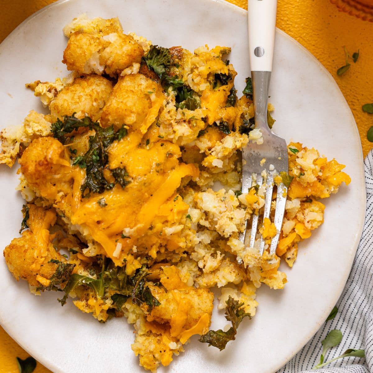 Up close shot of plate with baked tater tot casserole with a fork.