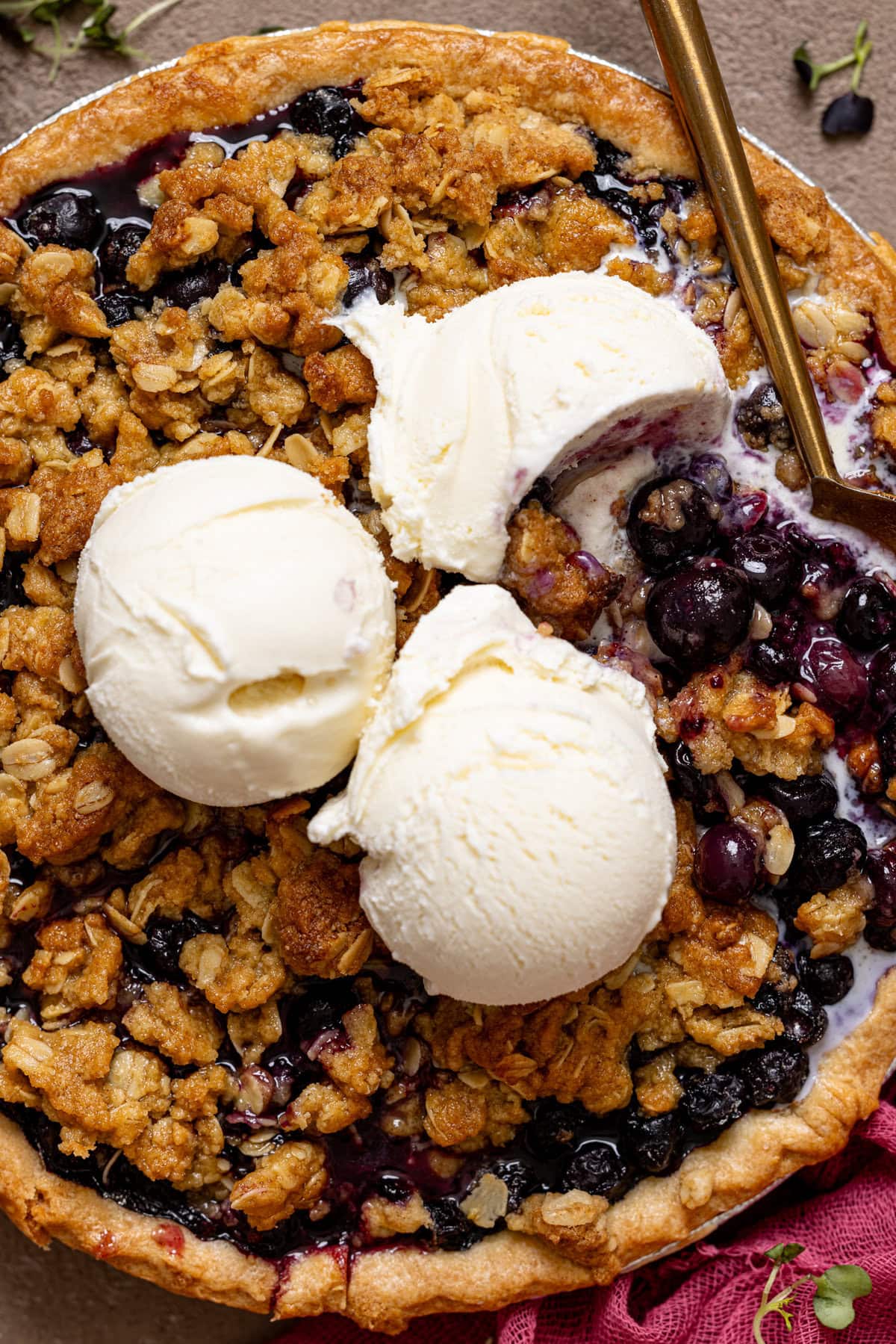 Up close shot of blueberry crumble pie with a spoon.