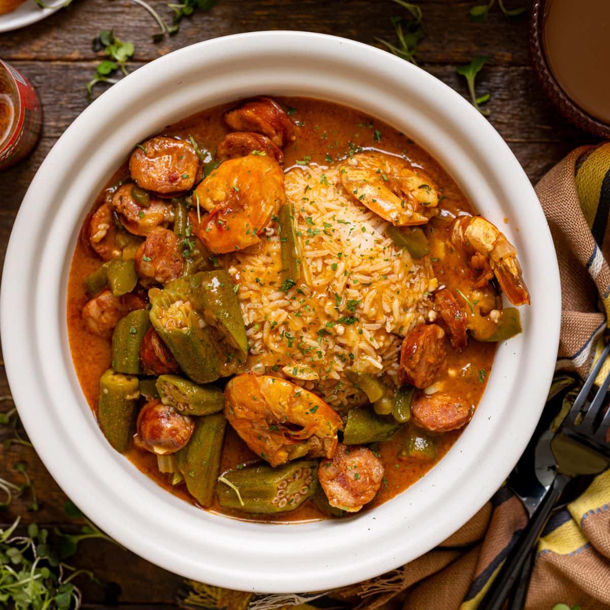 Up close shot of two bowls of gumbo with a fork + spoon.