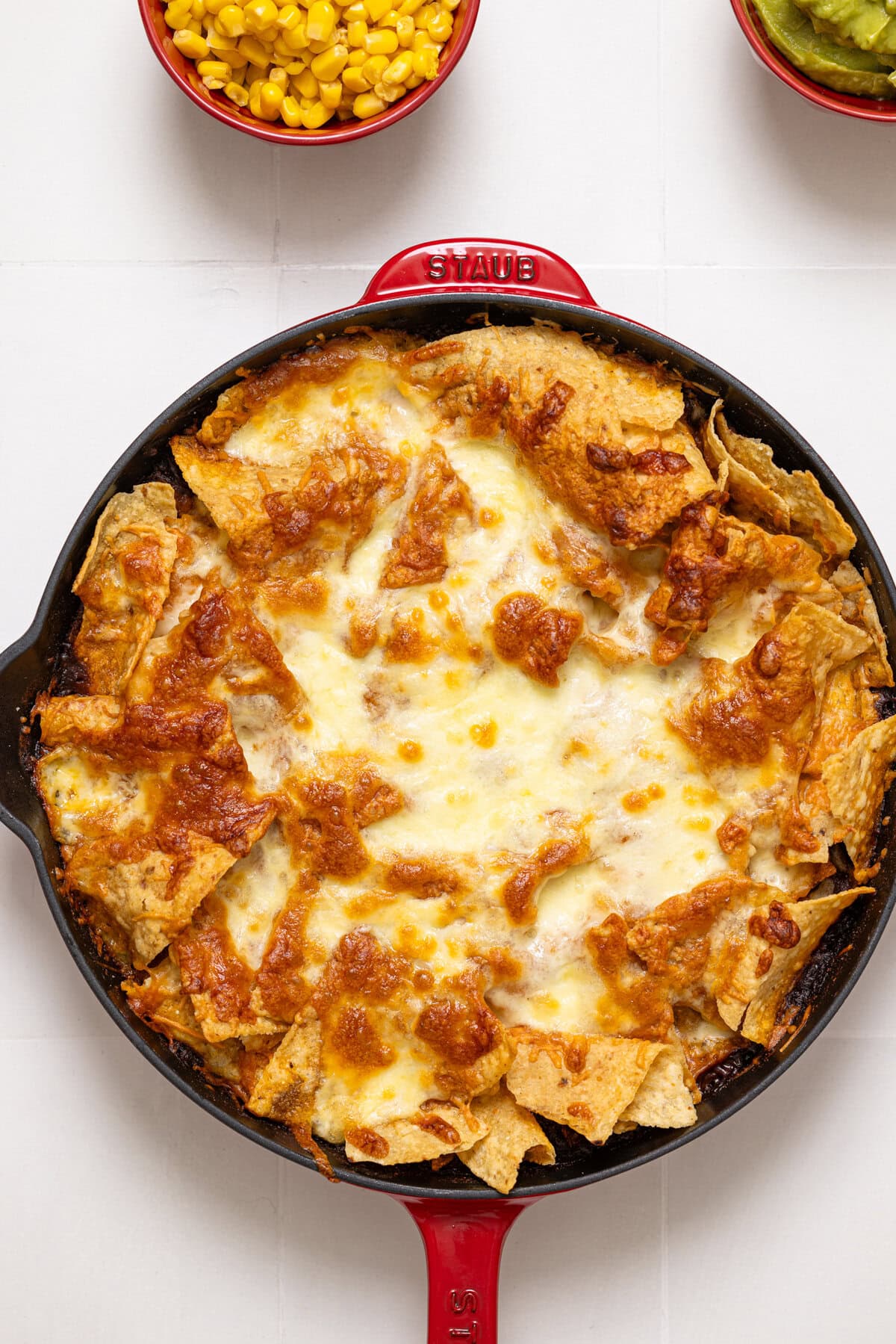 Baked skillet enchilada on a white tile table.