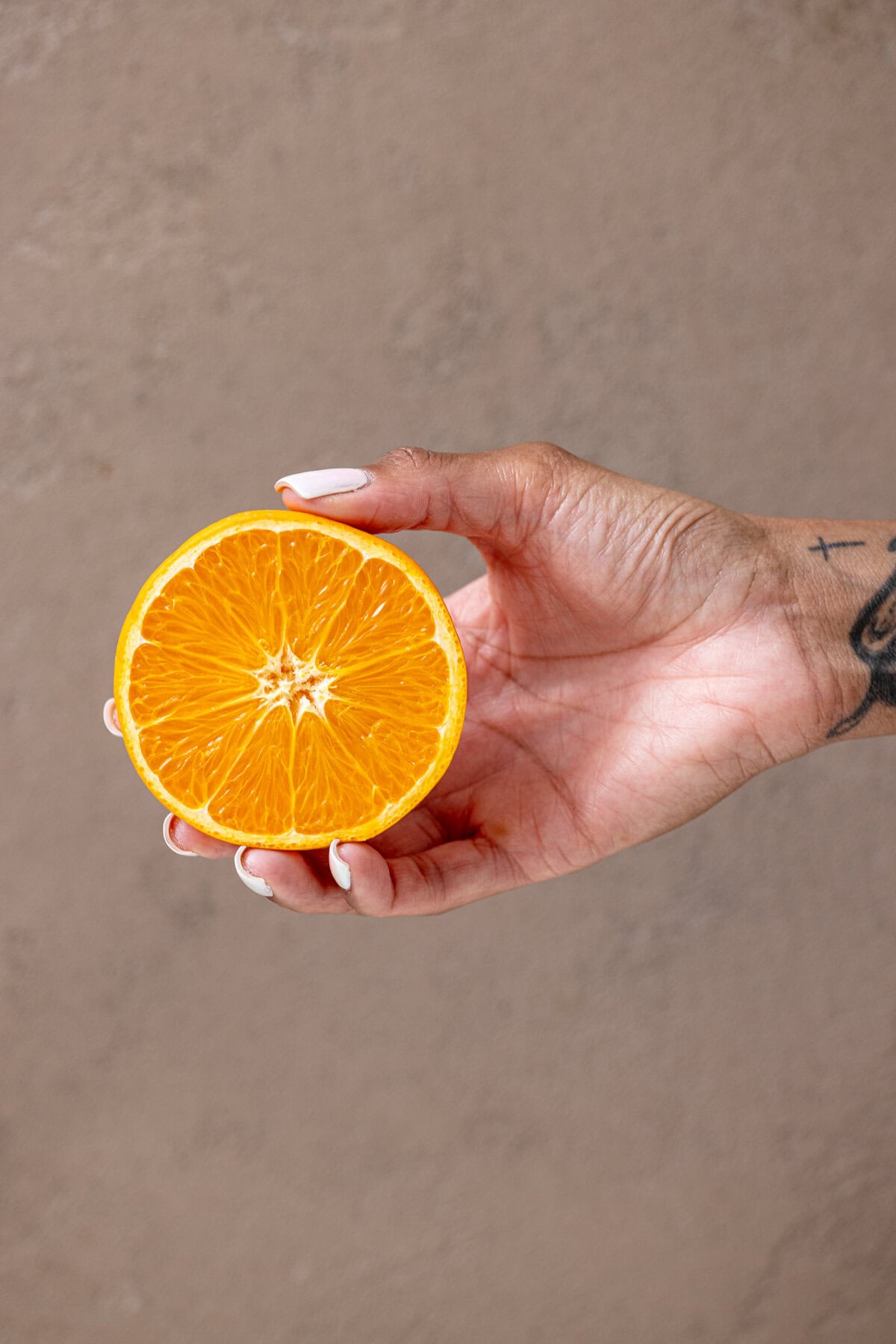 Halved orange being held with a female hand.